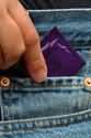 Fotografía de una persona metiendo un preservativo en el bosilllo de un pantalon tejano